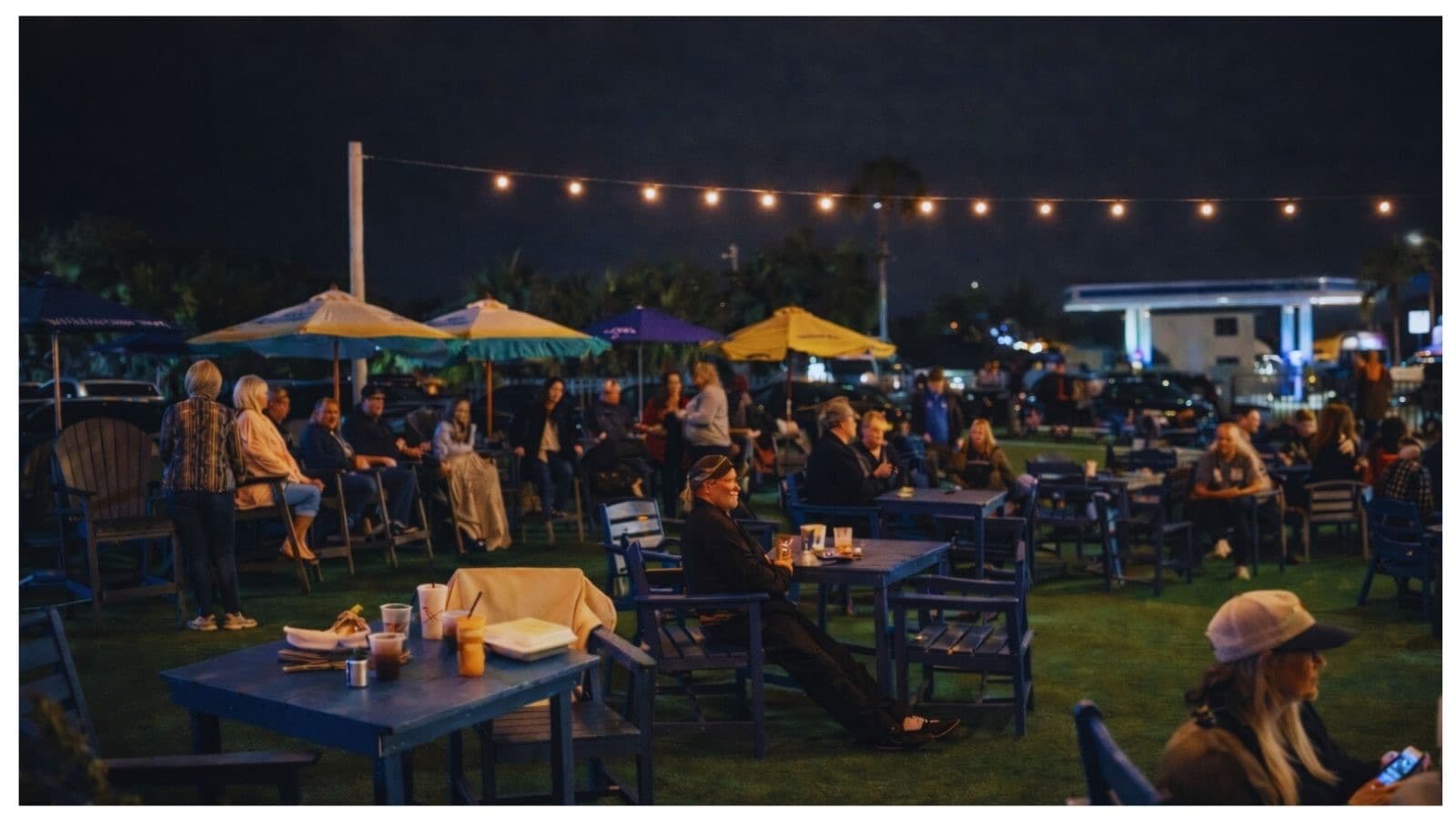 Salty Hobo's outdoor yard at night with string lights and a live music crowd